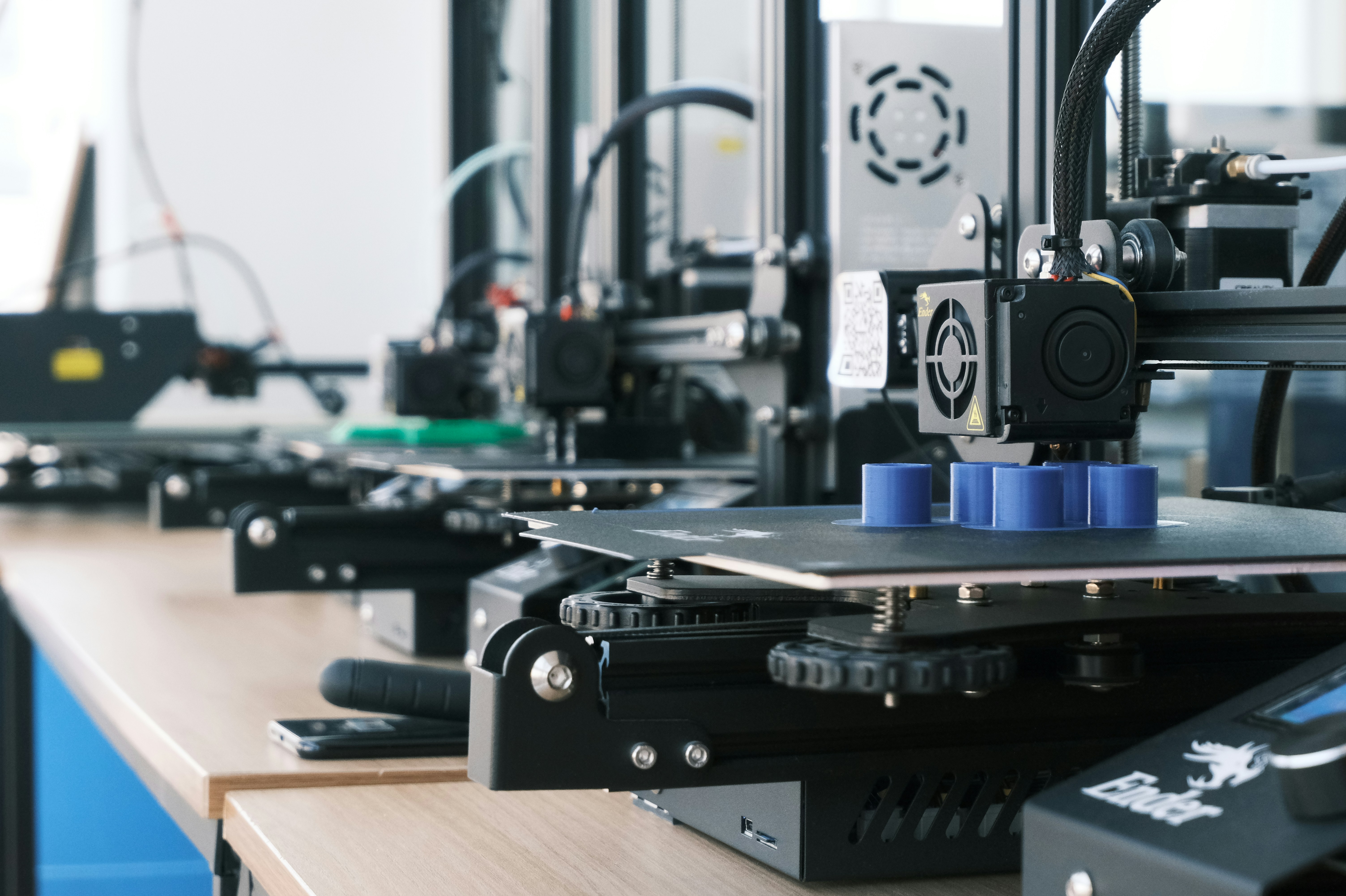Large-scale 3D print farm with multiple FDM printers running simultaneously for fleet management
